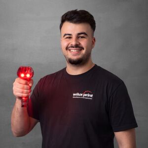 Shpend Dellova, Logistiker für Warenannahme und Spedition bei der WILUX PRINT AG, mit rotem Handscanner